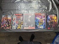 Front covers of six bagged and boarded Marvel comics laid side by side on table