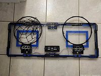 Full view of the wall-mounted double basketball hoop with rims, nets, and electronic score display
