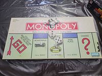 Monopoly board, two dice and metal car token displayed
