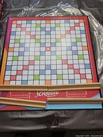 Scrabble board with four racks displayed on protective surface