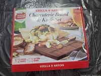 Front of sealed box showing Stella Artois charcuterie board & knife set with image and piece count