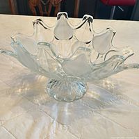 Angled view showing overall form, scalloped rim, pedestal base