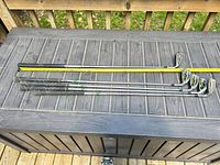 Full set of five clubs laid out with tape measure for length reference