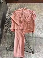 Pullover and pants laid on glass table showing full set