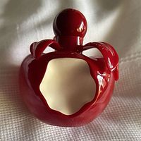 Front view of red apple-shaped perfume bottle with bite cutout
