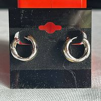 pair of sterling silver huggie earrings on display card