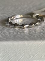 Side view of white gold ring showing raised diamond pattern