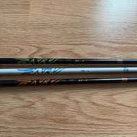 Three shafts laid side-by-side showing graphics and weights