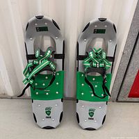 Full view of both Little Bear Trek 25 snowshoes showing color, bindings and overall condition