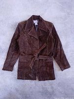 Front view of brown suede belted jacket laid flat