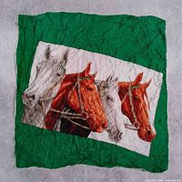 Full view of scarf laid flat displaying horse design and green border