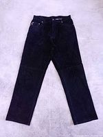 Full view of black suede leather pants laid flat