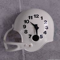 Full view of white football-helmet wall clock with numerals and hands