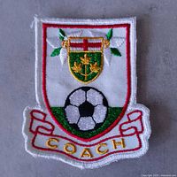 Front view of entire embroidered patch showing crest, soccer ball, and COACH text