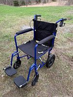 Full view of blue folding transport wheelchair