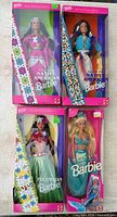 Group shot of four boxed Barbie dolls: Native American x2, Polynesian, Mermaid