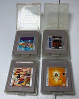 Overview of four Game Boy cartridges in clear cases