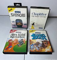 Front view of four Sega Genesis game cases: Shinobi, Choplifter, Alex Kidd High-Tech World, Altered Beast