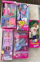 Group shot of all five boxed Barbie dolls