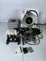 All items grouped: console, box, four controllers, cables, memory cards, white accessory