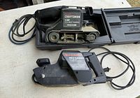 Both corded belt sanders, Craftsman in case, Black & Decker alongside