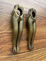 Front view of both brass nutcrackers showing leg shape and hinges