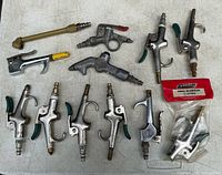 Lot overview showing twelve blowguns and brass nozzle