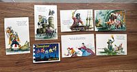 Seven pirate postcards and Disneyland Hi-Lites booklet arranged on table