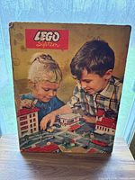 Front of LEGO System cardboard display with children scene