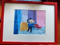 Entire framed artwork showing red metal frame, white mat and painting