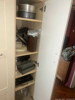 Cabinet showing multiple shelves of bakeware and cookware