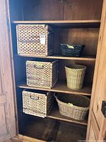Cabinet shelf showing six wicker baskets of assorted shapes and sizes