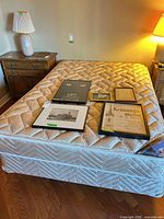 Full view of mattress and box spring on frame in room