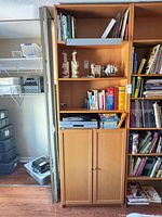 Full view of tall bookcase with shelves, cabinet doors, clip-on light
