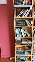 Full vertical view of one side of bookcase showing multiple shelves of assorted books