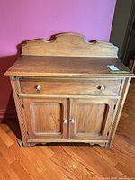 Front view of cabinet showing drawer, doors, backsplash, knobs