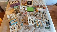 Overview of entire lot showing assorted jewelry pieces, trays and handbag