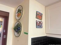 Wide view showing both ceramic plates and board artworks mounted on wall