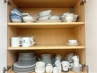 All three shelves showing full assortment of plates, bowls, mugs and serveware