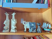 Full lot showing bookends, wood cat, metal cat bank, Formica art, model ship