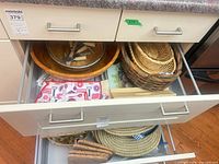 Drawer with wooden platter, wicker baskets, towel, trays, placemats