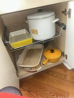 Cabinet showing stock pot, Copco pan, Descoware roaster and Le Creuset saucepan