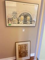 Both framed prints against wall, architectural print hung above, still life leaning below