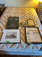 All five framed prints laid out on bed