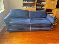 Front view of blue Simmons sofa with white piping