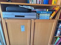 Toshiba combo unit, tape rewinder on top, remote and media beside