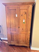 Front view of wood wardrobe showing two paneled doors
