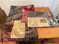 Runner and placemats stacked on table showing patchwork design