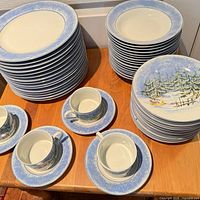 Stacks of dinner and dessert plates, teacups with saucers