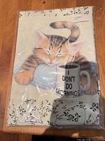 Front of packaged apron with cat graphic and slogan